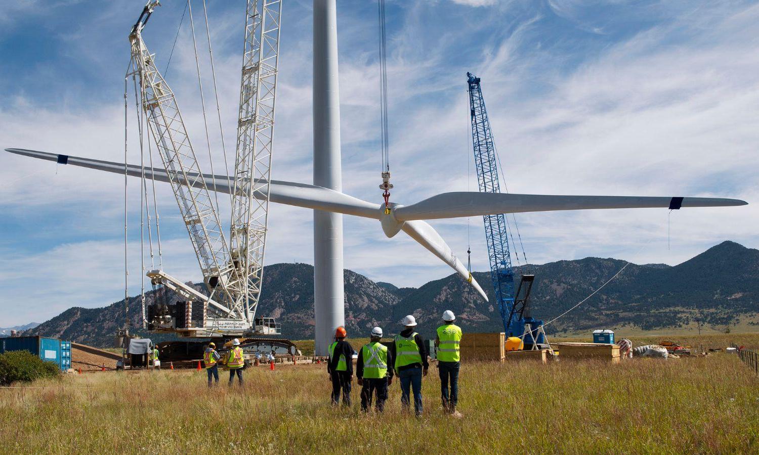 一群工人正在组装风力涡轮机.