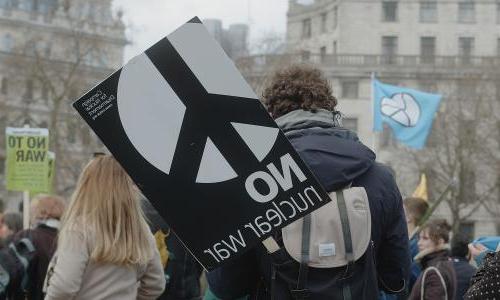  一名男子在伦敦特拉法加广场的集会上举着牌子, “没有核战争”, 争取核裁军, 支持处于战争中的乌克兰人民.